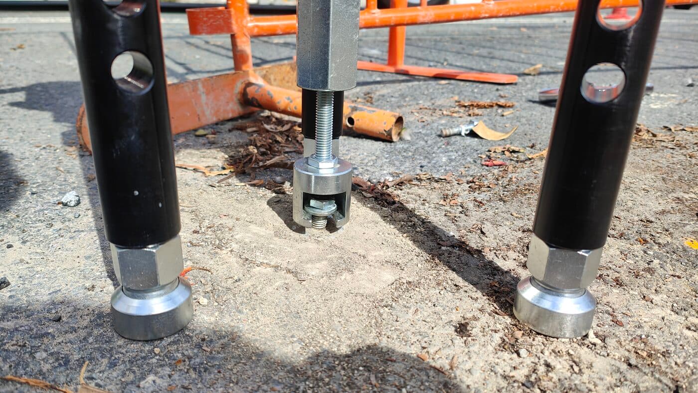 Close-up of Hydrajaws coupler and reaction legs engaging a screw anchor for tensile loading - Anchor Testing Australia